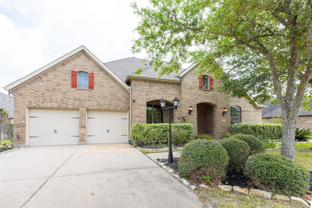 2715 Joshua Tree Ln, Manvel, TX 77578 - french country style house with brick siding, driveway, and a shingled roof