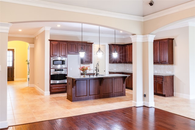 2715 Joshua Tree Ln, Manvel, TX 77578 - kitchen with stainless steel appliances, light tile patterned floors, a kitchen bar, light stone countertops, and ornamental molding