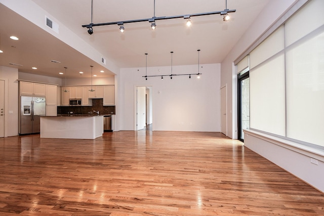 5005 Hidalgo St Unit 210, Houston, TX 77056 - unfurnished living room featuring track lighting, light wood-style floors, and recessed lighting