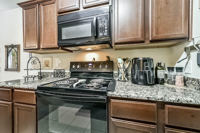 21118 Baltic Rain Dr, Hockley, TX 77447 - kitchen with black appliances, light stone counters, and tile patterned flooring