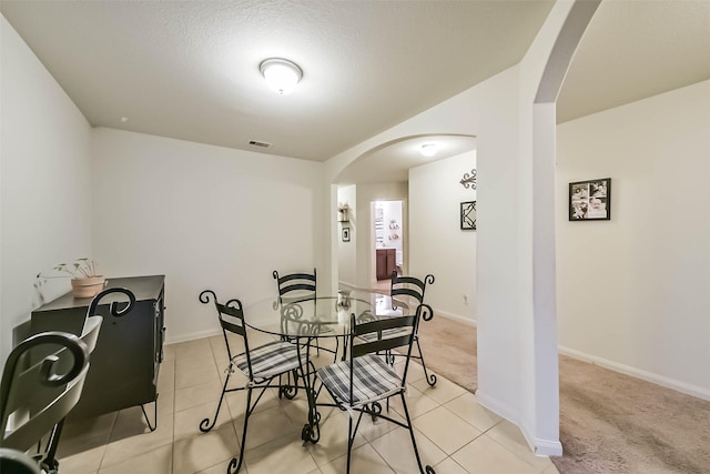 21118 Baltic Rain Dr, Hockley, TX 77447 - dining area with arched walkways, light colored carpet, and light tile patterned floors