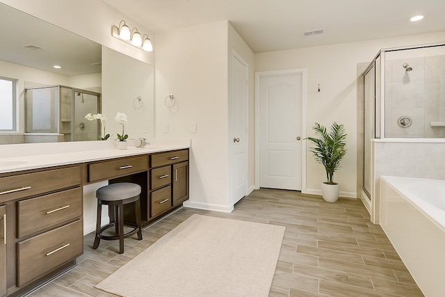 3905 Chartham Ln, Pearland, TX 77584 - full bath with double vanity, a shower stall, a garden tub, recessed lighting, and wood finished floors