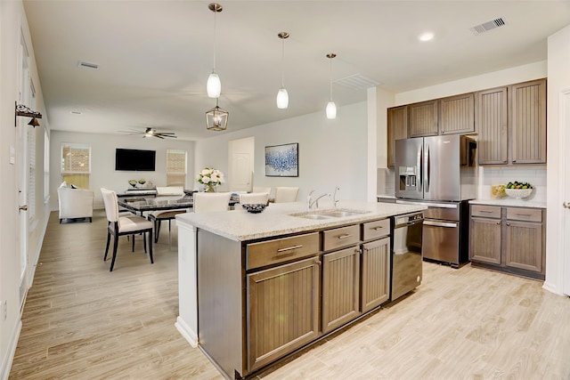 3905 Chartham Ln, Pearland, TX 77584 - kitchen with stainless steel refrigerator with ice dispenser, black dishwasher, light wood-style floors, ceiling fan, and pendant lighting