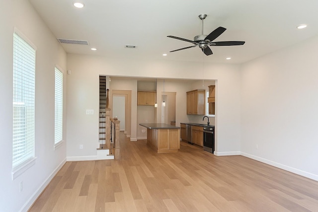 2519 S Houston Ave, Pearland, TX 77581 - kitchen featuring stainless steel dishwasher, light wood-style floors, dark countertops, open floor plan, and a ceiling fan