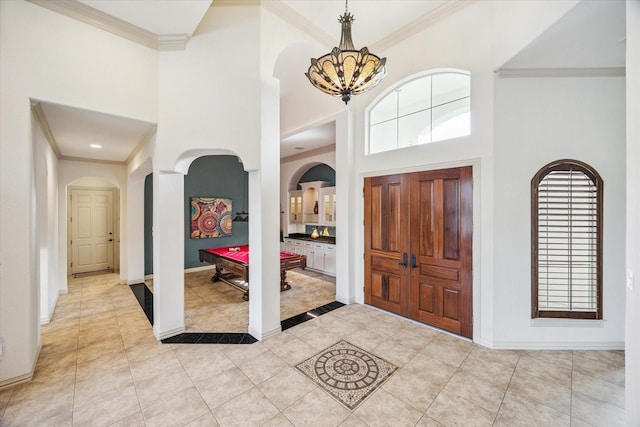 5214 Bristol Bank Ct, Houston, TX 77041 - foyer entrance featuring arched walkways, light tile patterned floors, a chandelier, ornamental molding, and a towering ceiling