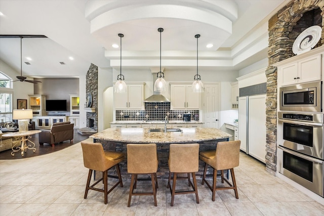 5214 Bristol Bank Ct, Houston, TX 77041 - kitchen featuring built in appliances, decorative backsplash, light tile patterned flooring, a kitchen bar, and recessed lighting