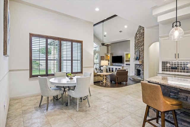 5214 Bristol Bank Ct, Houston, TX 77041 - dining room with a ceiling fan, a stone fireplace, recessed lighting, light tile patterned floors, and high vaulted ceiling