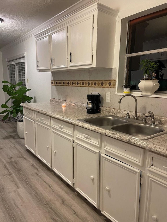 6101 Maywood Dr, Houston, TX 77053 - kitchen with light wood-style floors, ornamental molding, light countertops, decorative backsplash, and a textured ceiling