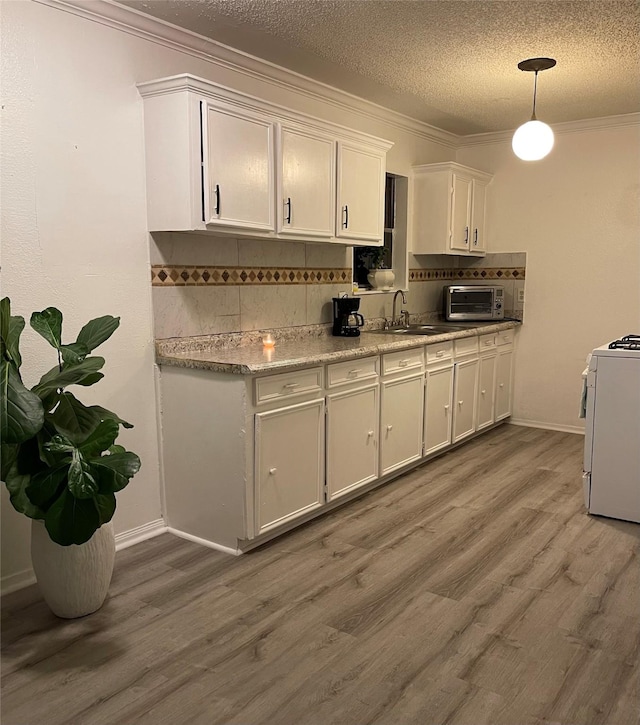 6101 Maywood Dr, Houston, TX 77053 - kitchen with white stove, stainless steel microwave, light countertops, decorative backsplash, and light wood-type flooring