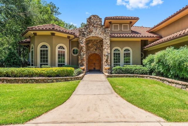 4022 Hidden Winds Dr, Spring, TX 77386 - mediterranean / spanish-style home featuring stucco siding, a front lawn, and a tiled roof