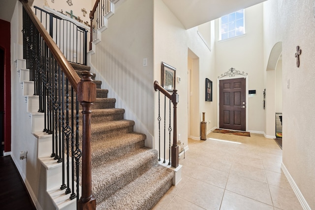 7910 Brooks Crossing Dr, Baytown, TX 77521 - foyer with a high ceiling, light tile patterned floors, stairs, and arched walkways