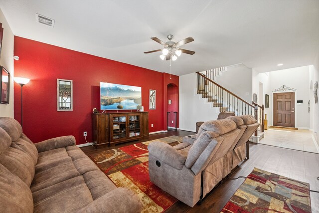 7910 Brooks Crossing Dr, Baytown, TX 77521 - living area featuring stairway, arched walkways, ceiling fan, an accent wall, and wood finished floors
