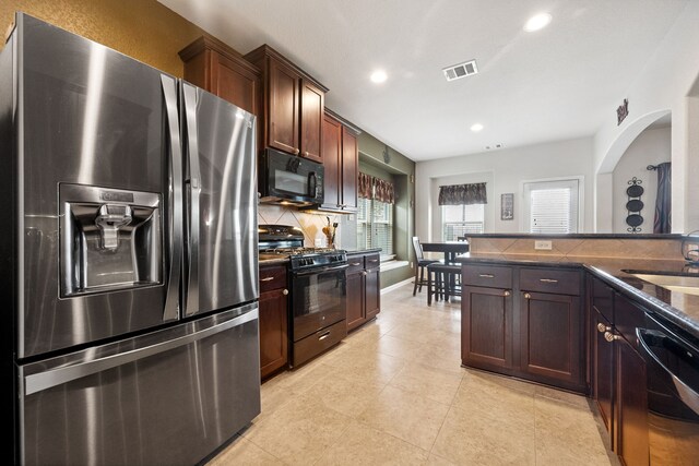 7910 Brooks Crossing Dr, Baytown, TX 77521 - kitchen with black appliances, decorative backsplash, recessed lighting, light tile patterned floors, and dark brown cabinetry