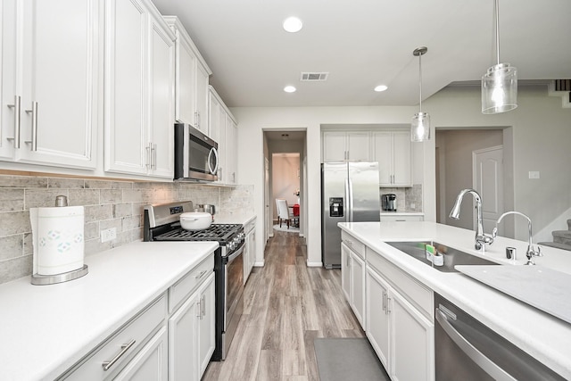 25915 Native Sapphire Ct, Richmond, TX 77406 - kitchen with stainless steel appliances, light wood-style floors, white cabinets, light countertops, and recessed lighting