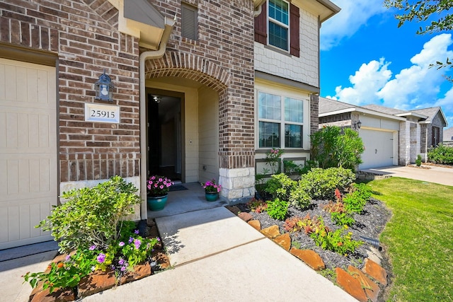 25915 Native Sapphire Ct, Richmond, TX 77406 - view of exterior entry with brick siding, an attached garage, and concrete driveway