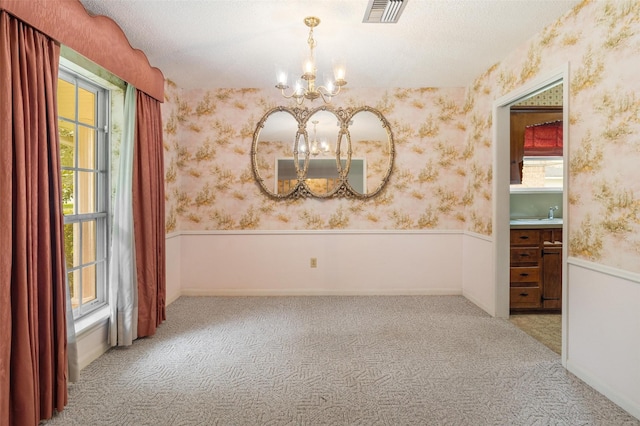 2718 Stratford St, Pearland, TX 77581 - carpeted spare room featuring a chandelier, wallpapered walls, a wainscoted wall, and a textured ceiling