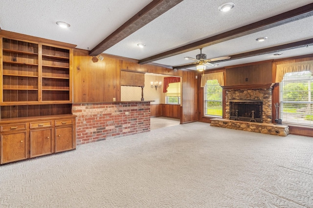 2718 Stratford St, Pearland, TX 77581 - unfurnished living room featuring light colored carpet, wooden walls, healthy amount of natural light, a textured ceiling, and a ceiling fan