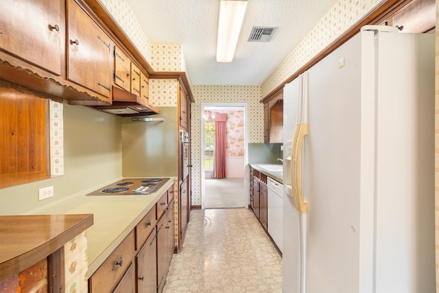2718 Stratford St, Pearland, TX 77581 - kitchen featuring white appliances, under cabinet range hood, light countertops, light floors, and wallpapered walls