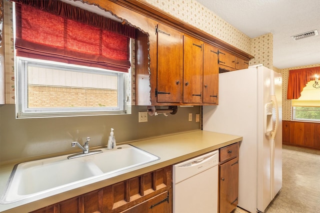 2718 Stratford St, Pearland, TX 77581 - kitchen featuring white appliances, wallpapered walls, light countertops, and brown cabinetry