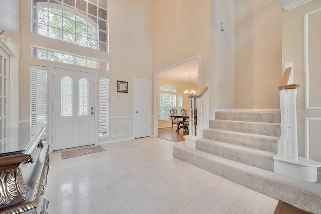 4106 Alice Dr, Sugar Land, TX 77478 - foyer with a towering ceiling, a chandelier, stairs, wainscoting, and a decorative wall
