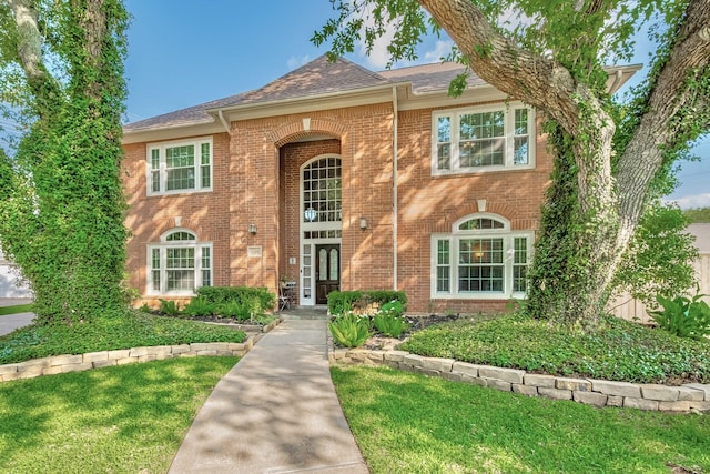 4106 Alice Dr, Sugar Land, TX 77478 - traditional-style house featuring brick siding, a front lawn, and a shingled roof