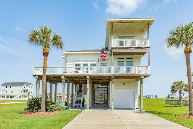18614 Warrior Rd, Galveston, TX 77554 - beach home featuring a garage, a front lawn, concrete driveway, a balcony, and stairway