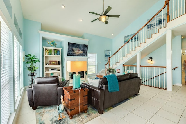 18614 Warrior Rd, Galveston, TX 77554 - living area featuring a ceiling fan, stairs, tile patterned flooring, and high vaulted ceiling