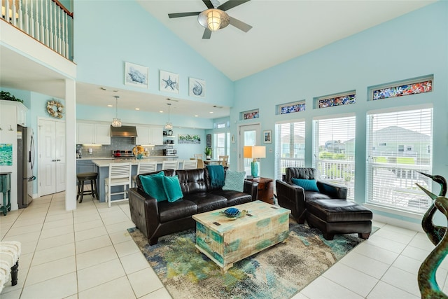 18614 Warrior Rd, Galveston, TX 77554 - living room featuring light tile patterned flooring, ceiling fan, high vaulted ceiling, and healthy amount of natural light