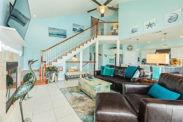 18614 Warrior Rd, Galveston, TX 77554 - living area featuring high vaulted ceiling, light tile patterned floors, stairway, ceiling fan, and a fireplace