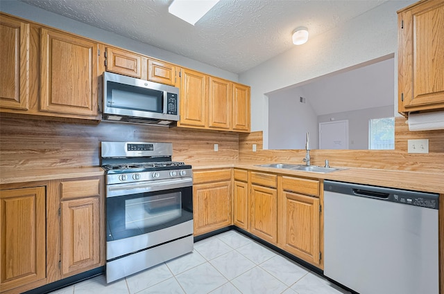 2415 Pebbledowne Cir, Sugar Land, TX 77478 - kitchen featuring appliances with stainless steel finishes, light countertops, backsplash, light tile patterned floors, and a textured ceiling