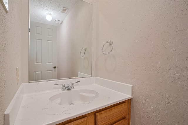 2415 Pebbledowne Cir, Sugar Land, TX 77478 - bathroom featuring vanity, a textured wall, and a textured ceiling