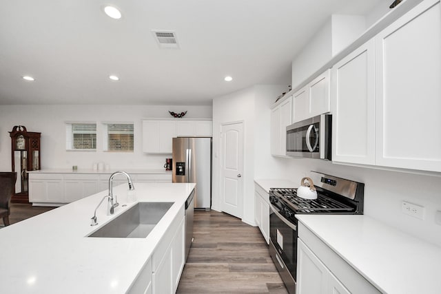 4985 Blue Beetle Ridge Dr, Katy, TX 77493 - kitchen with stainless steel appliances, dark wood-style flooring, recessed lighting, white cabinets, and light countertops