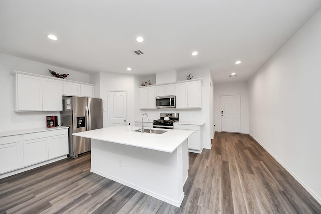 4985 Blue Beetle Ridge Dr, Katy, TX 77493 - kitchen with appliances with stainless steel finishes, dark wood finished floors, a center island with sink, white cabinets, and recessed lighting