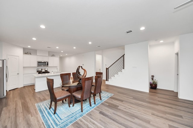 4985 Blue Beetle Ridge Dr, Katy, TX 77493 - dining area featuring recessed lighting, light wood-type flooring, and stairs