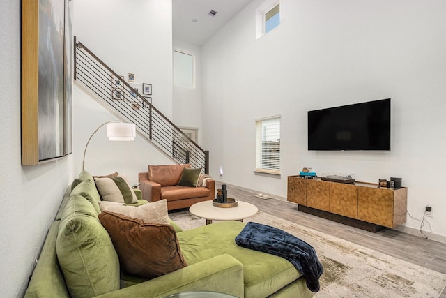12810 Barnesbury Ln, Houston, TX 77047 - living area featuring stairway, plenty of natural light, wood finished floors, and a towering ceiling