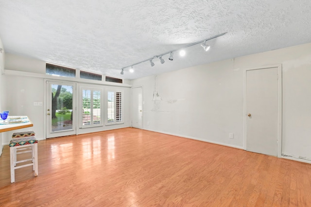 1202 Fay Rd, Kemah, TX 77565 - unfurnished living room featuring wood finished floors, a textured ceiling, and track lighting