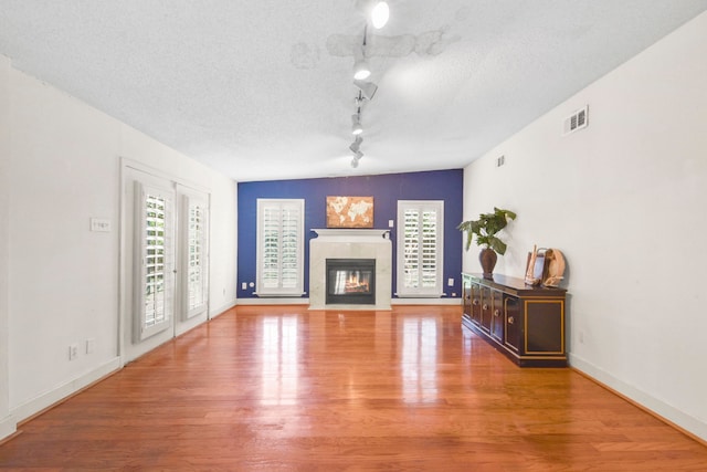 1202 Fay Rd, Kemah, TX 77565 - living room with wood finished floors, a tiled fireplace, and track lighting