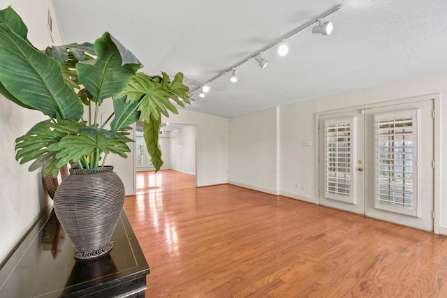 1202 Fay Rd, Kemah, TX 77565 - spare room with wood finished floors, track lighting, french doors, and a textured ceiling
