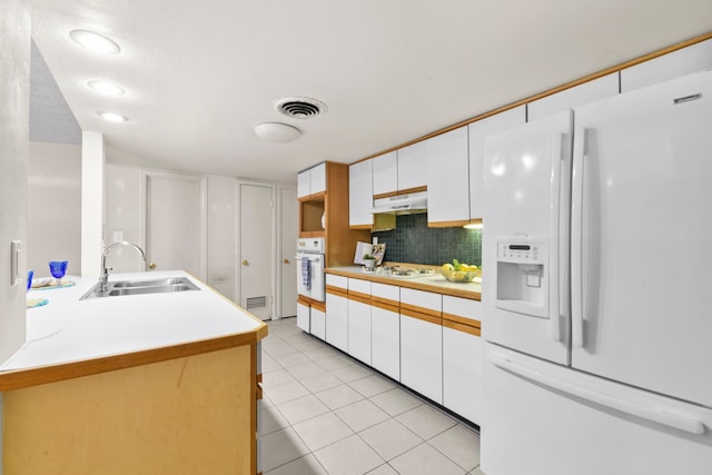 1202 Fay Rd, Kemah, TX 77565 - kitchen featuring white appliances, light tile patterned flooring, white cabinetry, light countertops, and tasteful backsplash