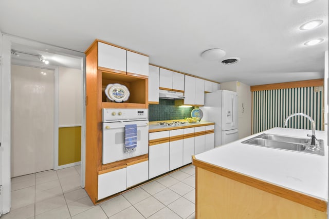 1202 Fay Rd, Kemah, TX 77565 - kitchen featuring white appliances, under cabinet range hood, white cabinetry, light countertops, and tasteful backsplash