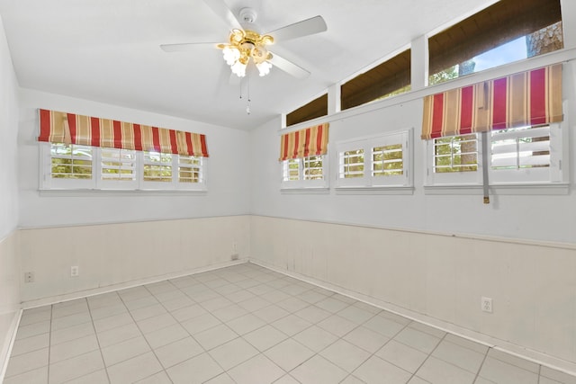 1202 Fay Rd, Kemah, TX 77565 - spare room featuring a ceiling fan, lofted ceiling, a wainscoted wall, and tile patterned flooring