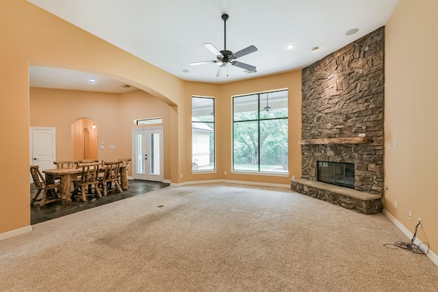 26150 Crown Ranch Blvd, Montgomery, TX 77316 - unfurnished living room with carpet, arched walkways, a ceiling fan, a fireplace, and recessed lighting