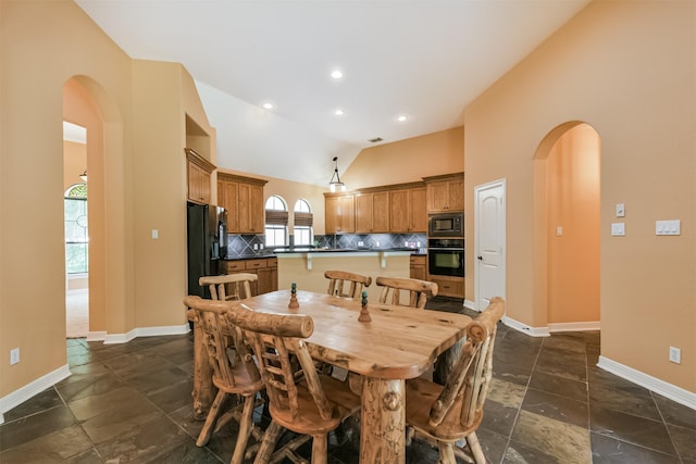 26150 Crown Ranch Blvd, Montgomery, TX 77316 - dining area featuring arched walkways, vaulted ceiling, stone tile flooring, and recessed lighting