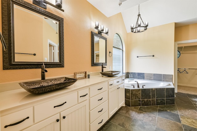 26150 Crown Ranch Blvd, Montgomery, TX 77316 - bathroom featuring double vanity, a bath, a chandelier, stone tile flooring, and vaulted ceiling