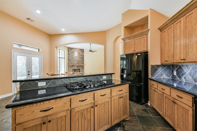 26150 Crown Ranch Blvd, Montgomery, TX 77316 - kitchen featuring black appliances, arched walkways, backsplash, recessed lighting, and a stone fireplace
