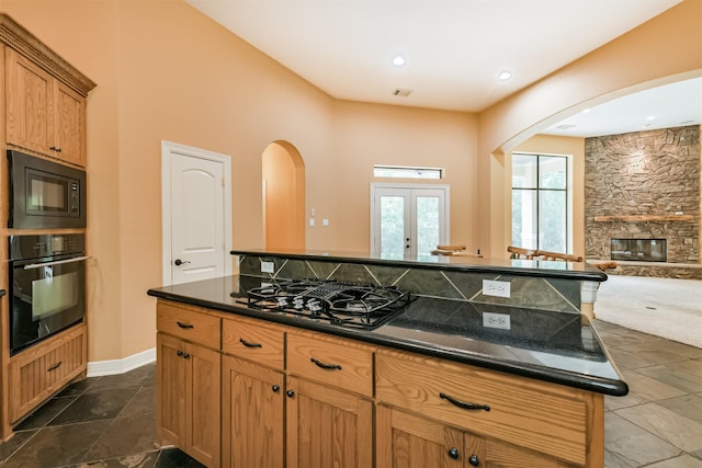26150 Crown Ranch Blvd, Montgomery, TX 77316 - kitchen with black appliances, arched walkways, open floor plan, french doors, and a center island