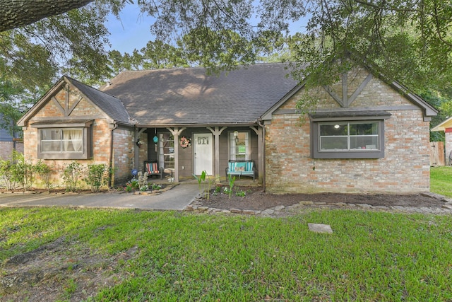 637 Mosswood Dr, Conroe, TX 77302 - view of front of home with a front yard, brick siding, a shingled roof, and a porch