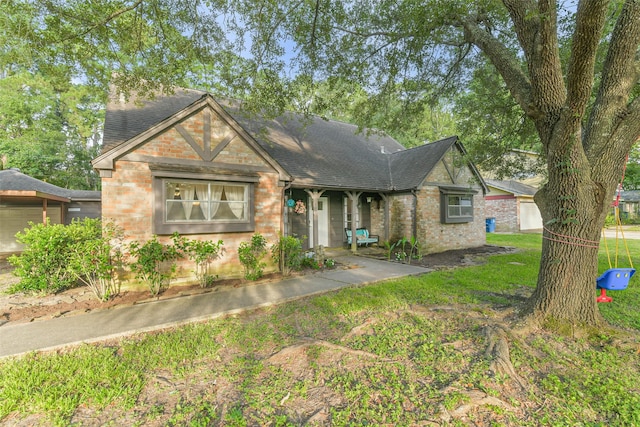 637 Mosswood Dr, Conroe, TX 77302 - tudor-style house with brick siding, roof with shingles, and a front yard
