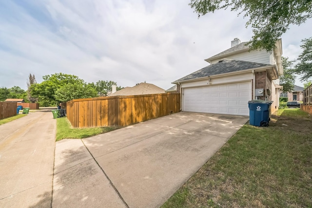 412 Belmont Ct, Lewisville, TX 75067 - view of home's exterior featuring concrete driveway, an attached garage, and a chimney