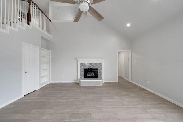 412 Belmont Ct, Lewisville, TX 75067 - unfurnished living room featuring high vaulted ceiling, a ceiling fan, a fireplace, wood finished floors, and built in features